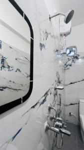 a marble bathroom with a shower and a sink at The Plaza - 100 feet Road, Near Indira Gandhi Statue, Pondicherry - JR Groups in Puducherry
