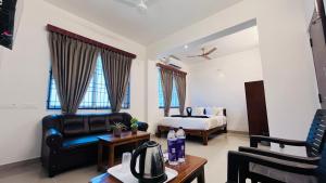 a living room with a bed and a couch and a table at The Plaza - 100 feet Road, Near Indira Gandhi Statue, Pondicherry - JR Groups in Puducherry +61 photos
