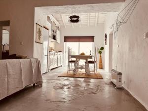a white room with a table and a kitchen at Cantinho do frade in Alandroal