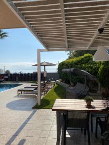 斯卡拉Villa Elizabeth的带桌椅和遮阳伞的露台