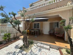 a patio with a table and an umbrella at Luxury Holiday Townhouse with Pool II Casa Macarena 02 in Ciudad Quesada