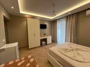 a bedroom with a bed and a desk and a television at Armando Apartments in Golem