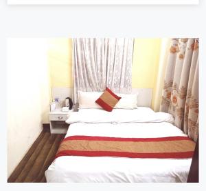 Una habitación de hotel con dos camas y una ventana. en Hotel Times, en Katmandú