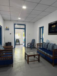 a living room with two couches and a coffee table at Liyaa Blue Beach Weligama in Weligama