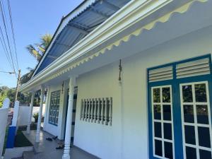 a white building with a blue door at Liyaa Blue Beach Weligama in Weligama