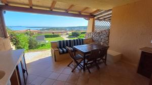 un patio con tavolo, sedie e un divano di Casa Verdiana Golfo di Marinella Sardegna a Marinella