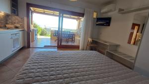 una camera da letto con un letto, una cucina e un tavolo di Casa Verdiana Golfo di Marinella Sardegna a Marinella