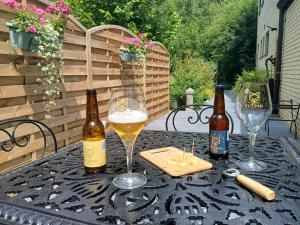 two bottles of beer and two glasses on a table at Le Loft du Renard, gîte cosy au coeur de la nature boisée à Namur Wépion, une parenthèse douce dans la vallée mosane in Namur +41 photos
