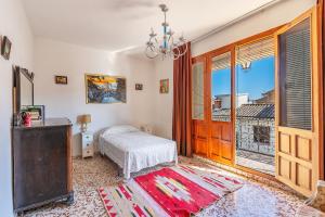 a bedroom with a bed and a large window at Casa Solariega con encanto in Padul