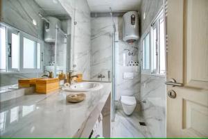 a white bathroom with a sink and a toilet at Saroko Apartment 1 in Agios Rokkos