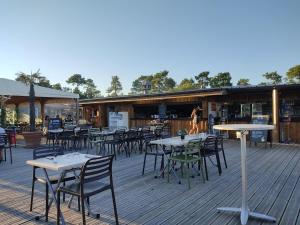 a group of tables and chairs on a deck at Un toit sur le bassin les viviers in Lège-Cap-Ferret