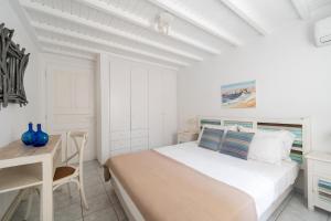 Un dormitorio blanco con una cama y un escritorio. en Villa Orea Beachfront by Mykonos Mood, en Kalafatis 21 fotos más