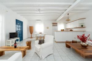 Una sala de estar con muebles blancos y una mesa. en Villa Orea Beachfront by Mykonos Mood, en Kalafatis
