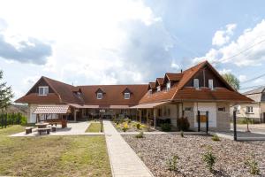 a large house with a brown roof at Mátravölgy Apartmanház in Pásztó