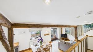 a living room with a couch and a table at The Cote is a stunning rural barn beach 3 miles in Haven Street