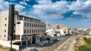 a city street with cars parked in front of a building at Qimam Park Hotel Al-baha 7 in Al Baha