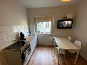a small kitchen with a table and a table and a television at EMAS 5 Wohnung mit 3 Einzelbetten, Küche in Krefeld