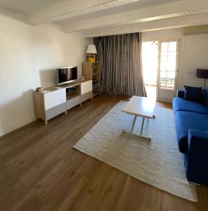 un salon avec un canapé bleu et une table dans l'établissement Emeraude, à Saint-Raphaël