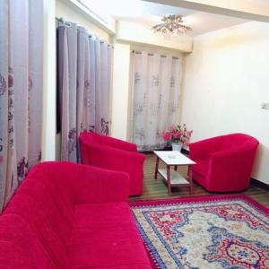 a living room with two red chairs and a table at Hotel Times in Kathmandu