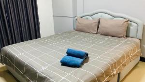 a bed with a blue pillow sitting on it at Phuket Town Condo 2 Bedroom with Balcony-Cats Friendly in Phuket Town