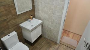 a bathroom with a white toilet and a sink at Апартаменти Bella Deluxe in Ravda +26 photos