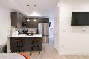 a kitchen with a sink and a counter with stools at Unit 1 Stylish Studio with King Bed and Sofa Bed in Washington