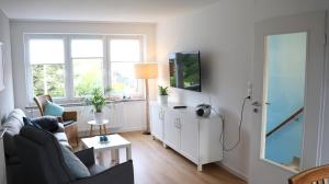 a living room with a couch and a tv at Ferienwohnung Seewiefke in Holtgast