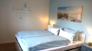 a bedroom with a couch with pillows and a sign at Ferienwohnung Seewiefke in Holtgast