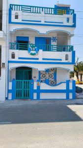 a blue and white building with a blue door at Villa Venba Sea View Stay in Puducherry