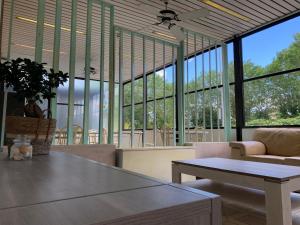 a living room with a table and chairs and windows at Smile Beach Hotel Nuova Gestione in Riccione