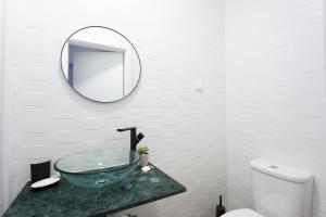 a bathroom with a glass sink and a mirror at Carcavelos Central Apartment in Carcavelos +27 photos