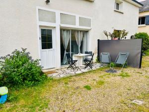 a patio with chairs and a table in front of a house at Maison entre Saumur et Montreuil Bellay La Motte in Artannes-sur-Thouet