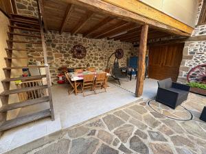 a patio with a table and chairs and a stone wall at Petite maison avec cour fermée in Beaulieu-sur-Dordogne