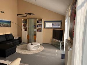 Una sala de estar con un sofá y un televisor. en Seemöwe, en Oberuhldingen