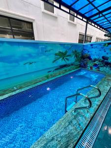 una piscina en un edificio con una pintura en la pared en Hotel Hải Âu, en Sầm Sơn