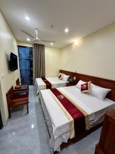 Una habitación de hotel con dos camas y un televisor. en Hotel Hải Âu, en Sầm Sơn