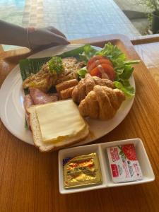 ein Teller mit Essen auf einem Holztisch in der Unterkunft Khaolak Beachhouse Kelolo in Khao Lak