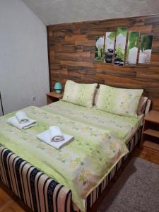 a bedroom with a bed with towels on it at Apartmani Popovic in Vrdnik +8 photos