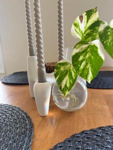 a table with three white vases and a plant at MZ apartment in Néa Péramos +18 photos