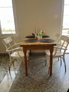 a dining room table with white chairs around it at MZ apartment in Néa Péramos