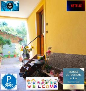 een geel huis met een tafel en een bord erop bij Gîte Les Acacias in Colmar