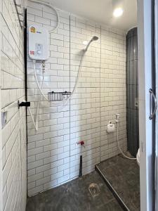 a bathroom with a shower with white tile walls at Chubby 9 Standard room in Ban Bang Phlat