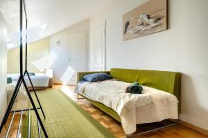 a bedroom with a bed and a green couch at Large and cozy 2-level apartment in Tallinn