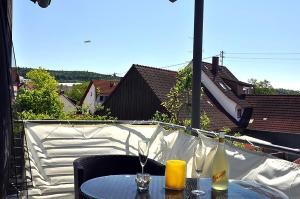 una mesa con copas de vino en el balcón en Seemöwe, en Oberuhldingen