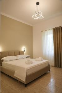 a bedroom with a large bed with a light at Garden Yard in Berat