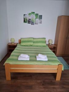 a bedroom with a bed with two towels on it at Apartmani Popovic in Vrdnik