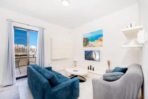 a living room with two blue chairs and a window at Seaview Promenade in Salina
