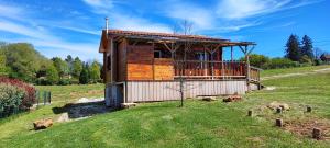 Saint-GenièsにあるLe nid des Garrigues avec Jacuzzi privéの緑地の丘の上の丸太小屋