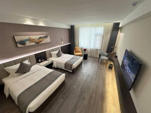 a hotel room with two beds and a flat screen tv at 巴域永源酒店 in Phumĭ Bavĕt (2) +8 photos