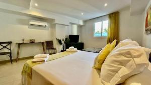 a bedroom with a large white bed with yellow pillows at Beach Panorama in Marbella